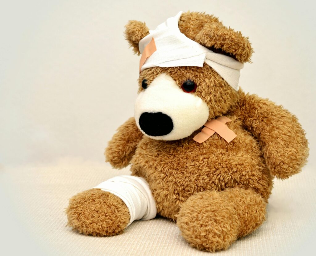 teddy-teddy-bear-association-ill-42230-42230 A brown teddy bear with bandages, depicting a playful take on injury recovery in a minimalist setting.
